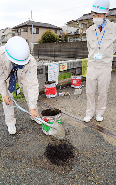 道路の損傷箇所を補修する市職員