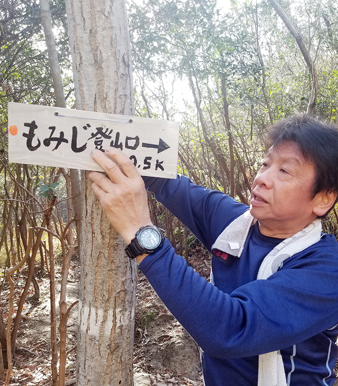 自作の道標プレートを設置する須田雄三さん