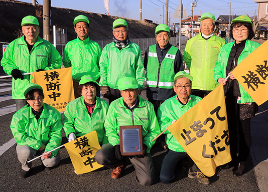 知事表彰を受けた大町自治会防犯パトロール隊。グリーンの帽子とジャンパーがトレードマーク